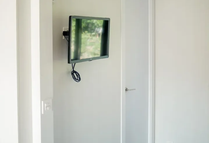 Aire acondicionado y televisor en pared de habitación moderna.