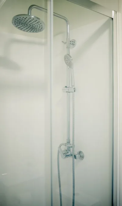 Ducha moderna con grifos y cabezal de ducha brillante y elegante.