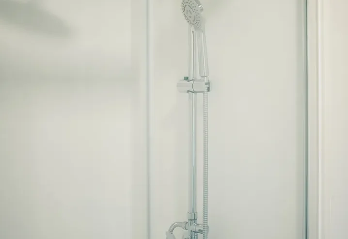 Ducha moderna con grifos y cabezal de ducha brillante y elegante.