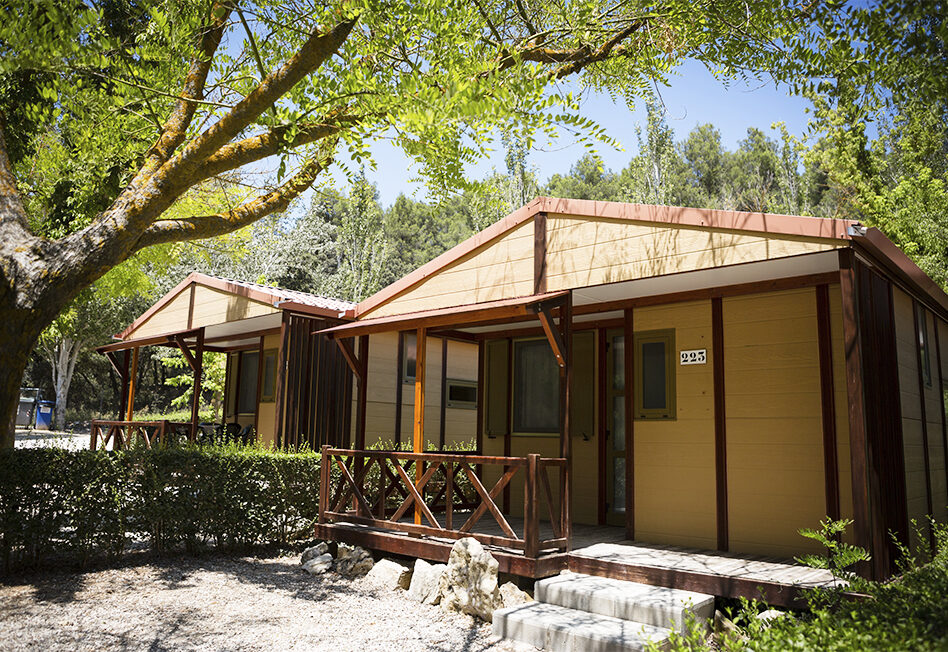 Cabañas de madera en un entorno natural y soleado.
