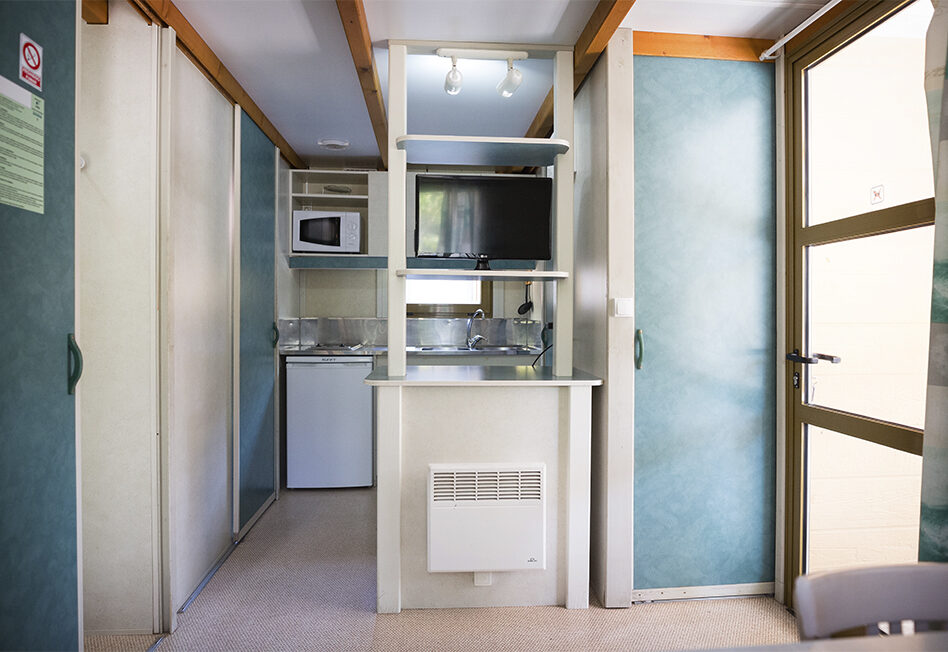 Cocina moderna pequeña con electrodomésticos en un entorno luminoso.