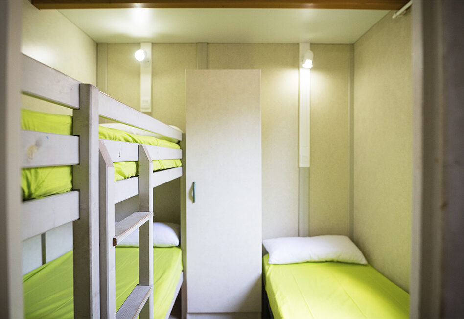 Habitación con literas y ropa de cama verde brillante.