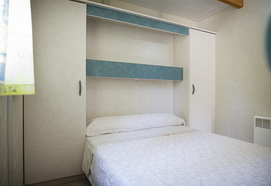 Habitación con cama y armario de estilo moderno.